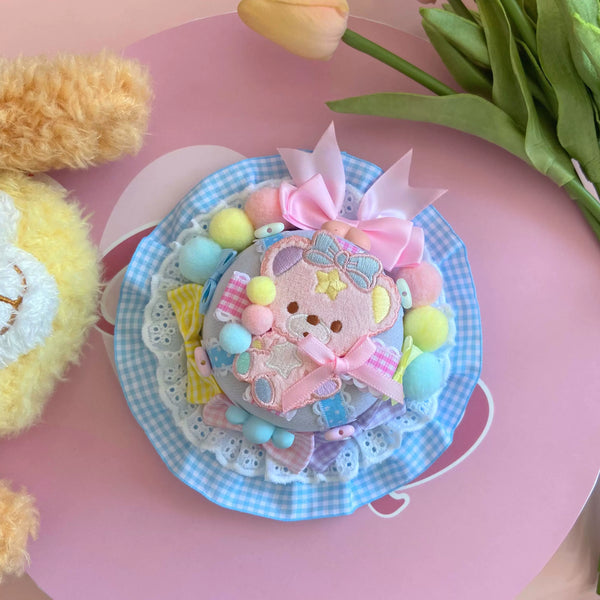 Pastel plaid headwear with layered lace, bows and a pink central motif.