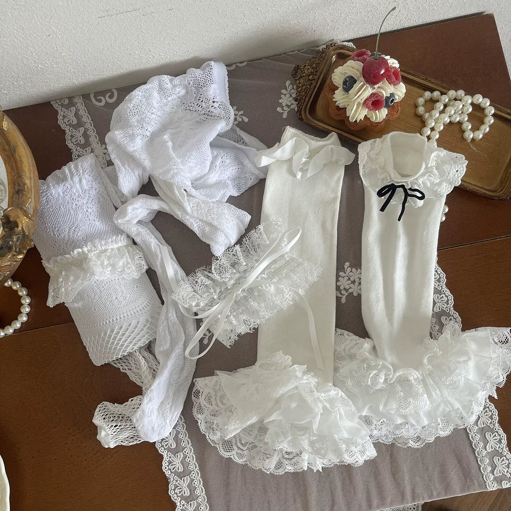 Layered white lace legwear with ruffled sock covers styled beneath a skirt
