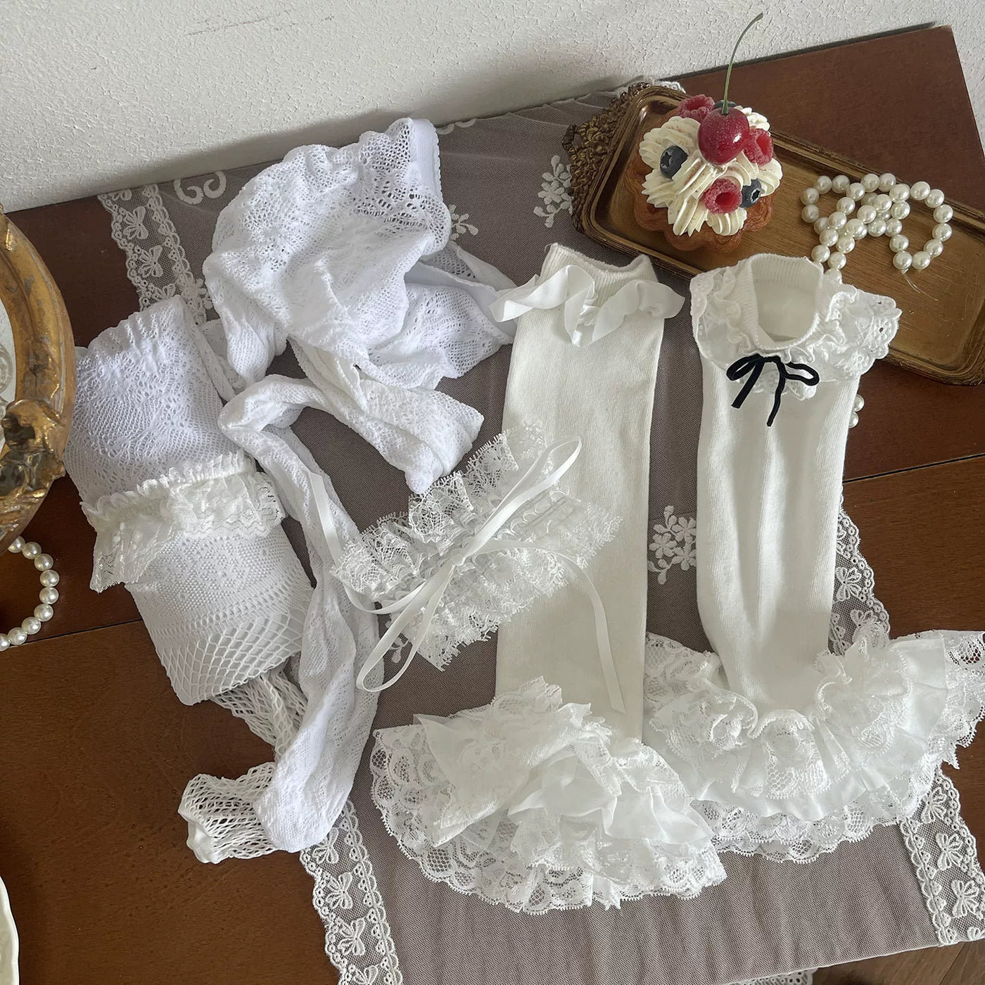 Layered white lace legwear with ruffled sock covers styled beneath a skirt