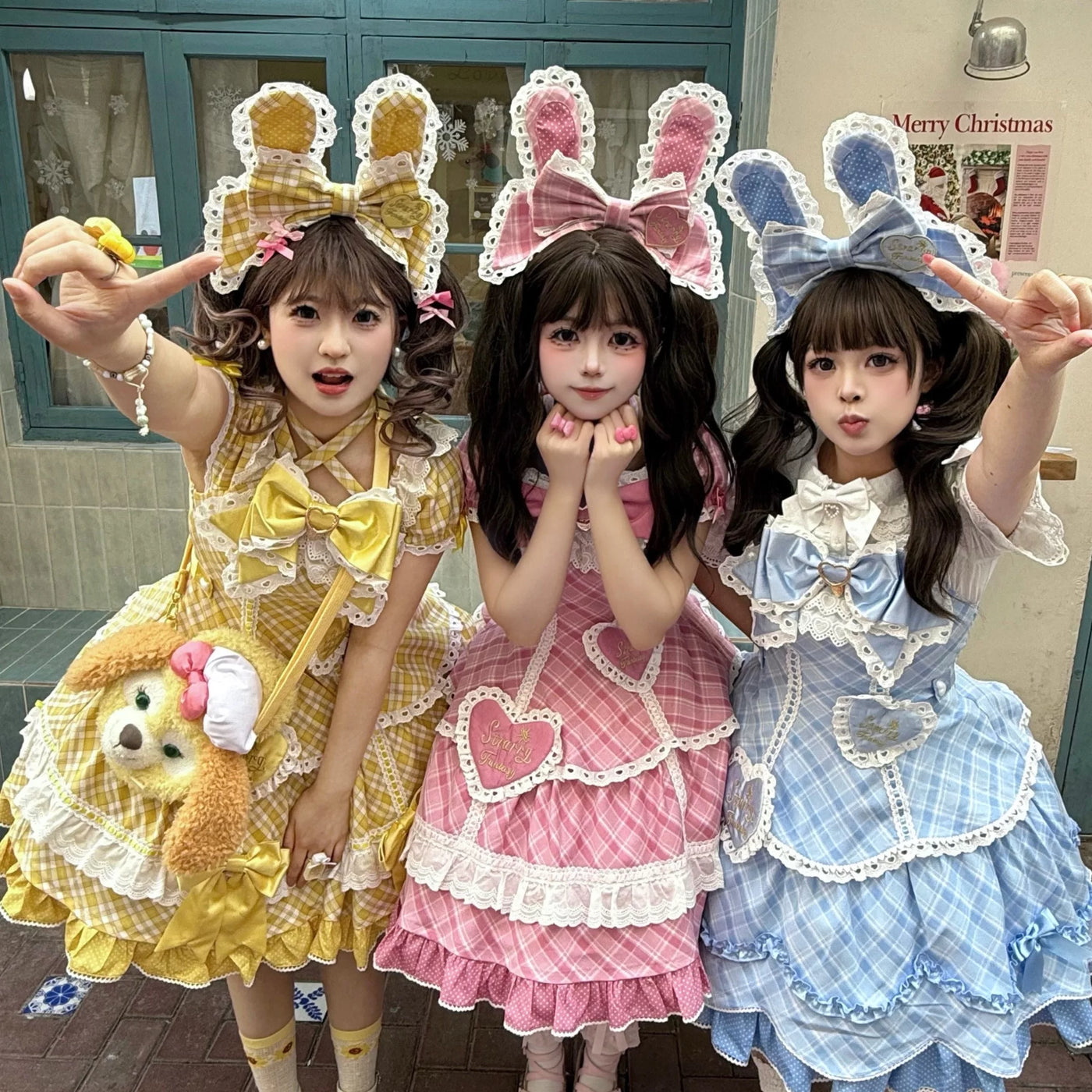 Three models wear pink, blue and yellow plaid OP or JSK dresses with oversized bows and lace bunny-ear headwear.