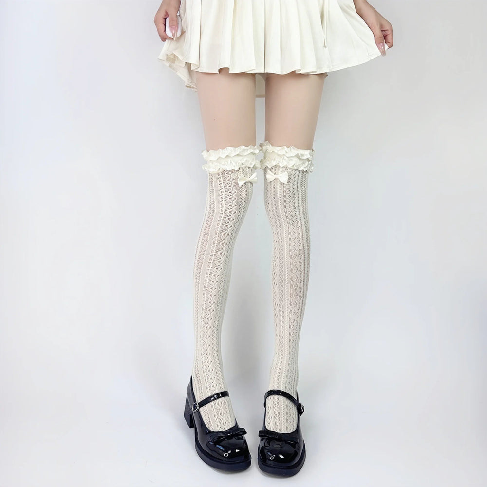 White openwork lace socks with ruffled tops and bows styled with black Mary Jane shoes