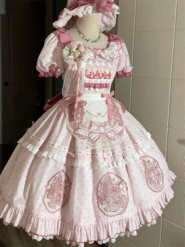 Pink strawberry-embroidered OP dress with apron displayed on a mannequin.