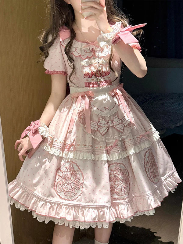 Front view of pink Sweet Lolita OP dress with strawberry embroidery, polka dots, lace trim, and matching apron