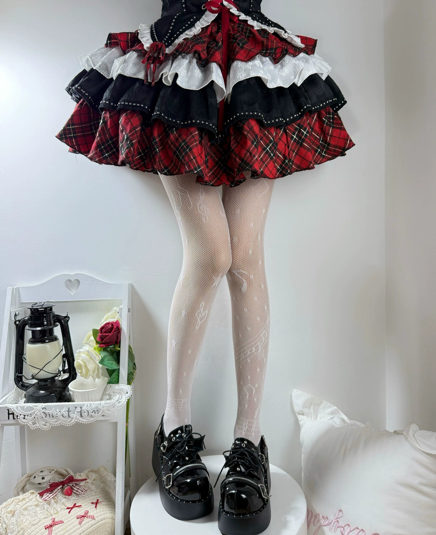 Black patterned fishnet tights with music-note motifs styled beneath a ruffled skirt.