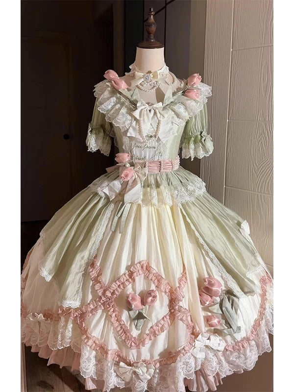 Green-and-pink short-sleeve Lolita dress with layered lace, bows and rose accents on a mannequin.