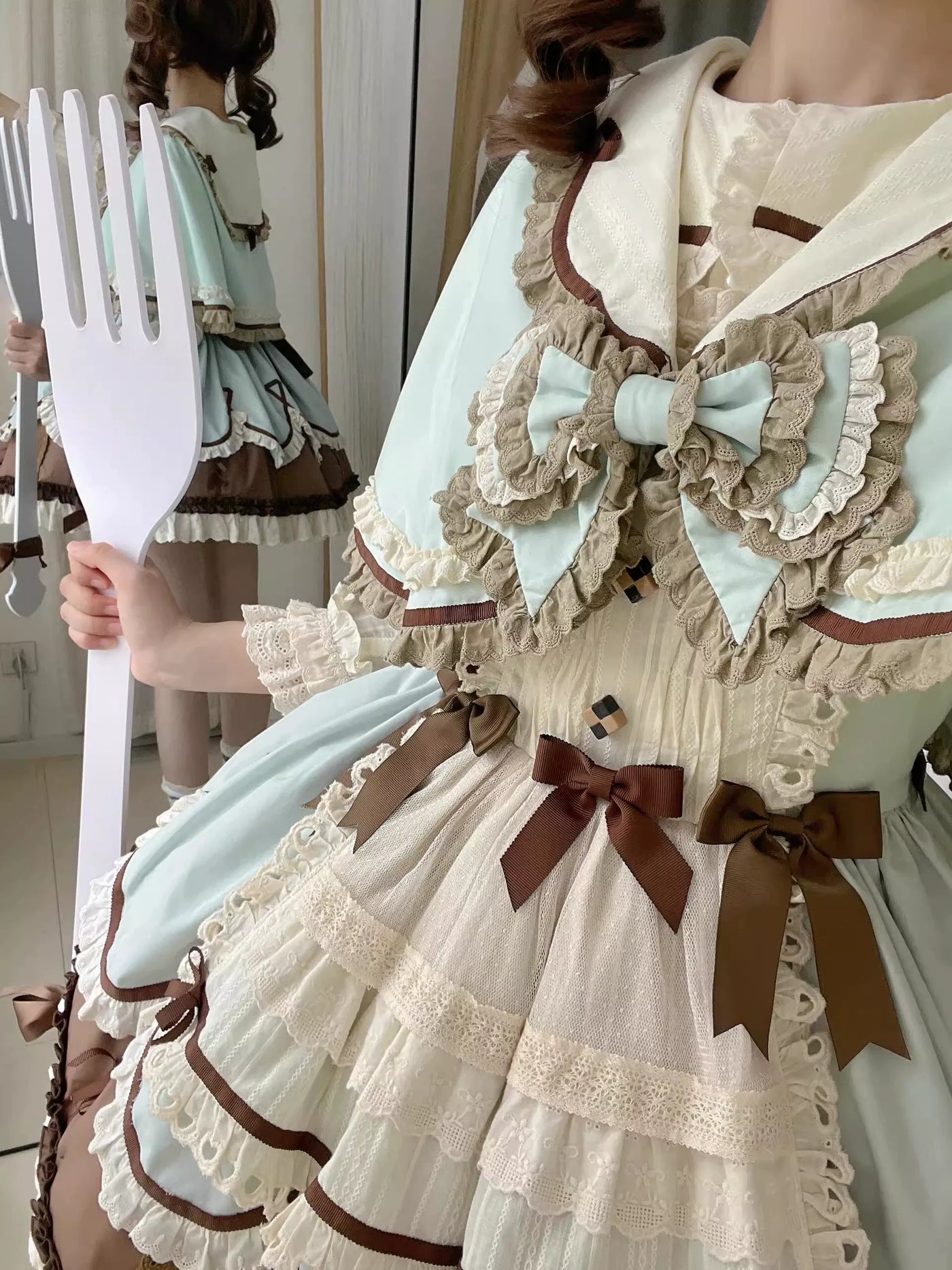Mint-and-cream JSK dress set with scalloped cape and brown ribbon details on a model