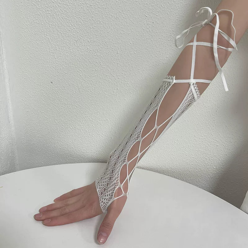 Sock Noble black and white lace arm sleeves with open latticework and tie straps, shown on a hand and arm.