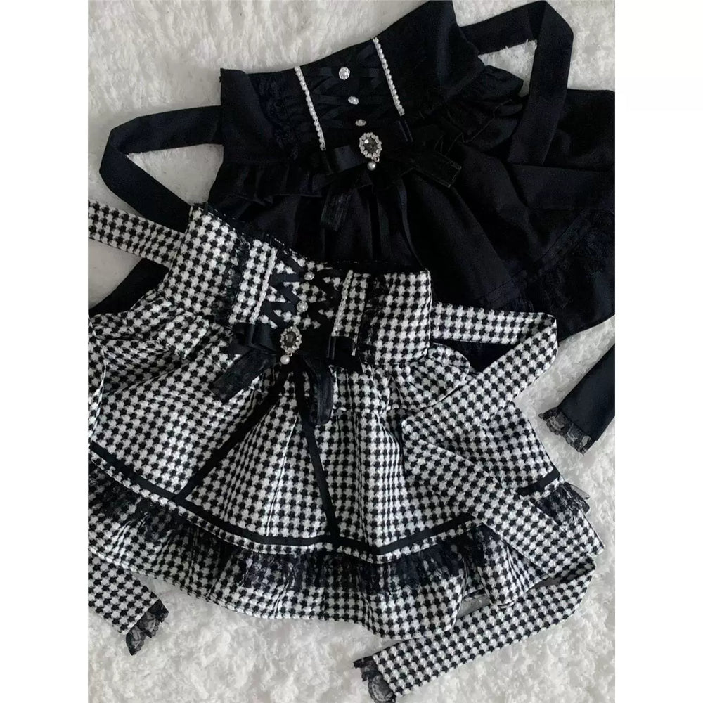 Black and houndstooth skirts with included bows and lace trim laid flat