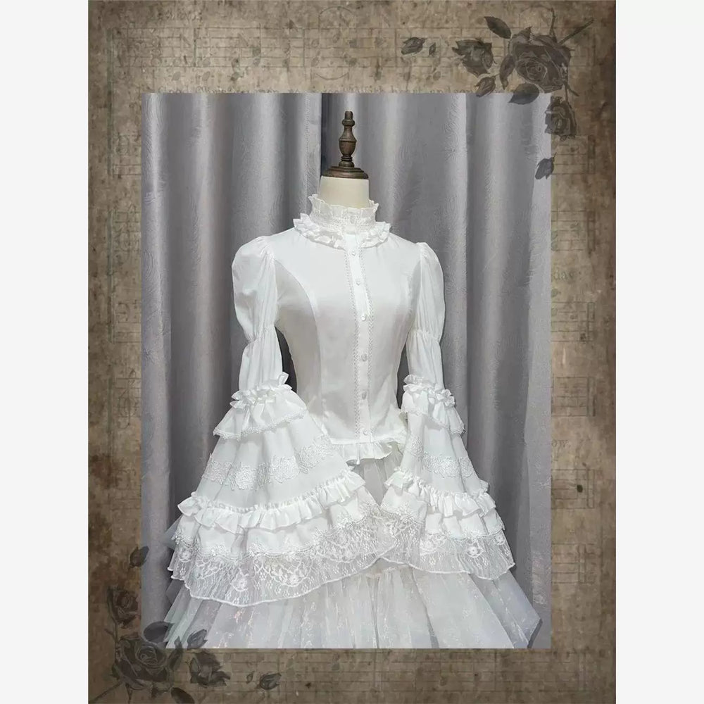 White and black ruffled blouses with lace trim, front buttons, and gathered puff sleeves.