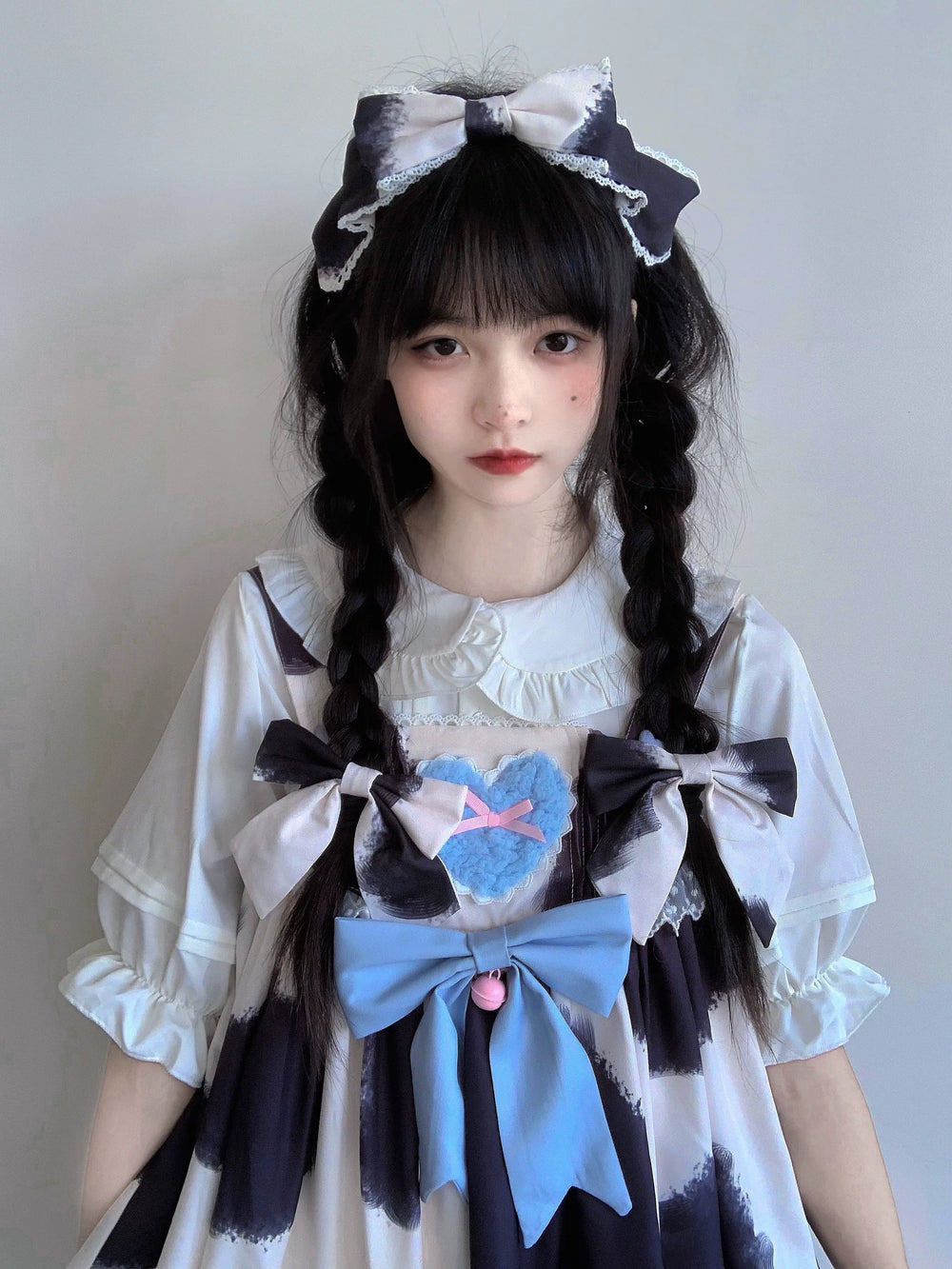 White doll-collar blouse layered beneath a black, white and blue dress.