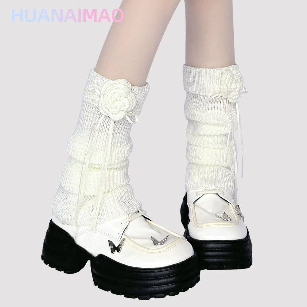 Light brown ribbed knit leg warmer with crochet floral appliqué and ribbon tie
