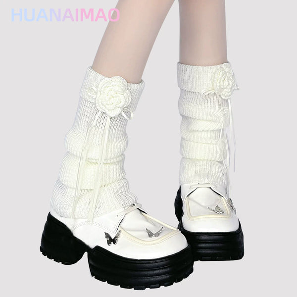 Light brown ribbed knit leg warmer with crochet floral appliqué and ribbon tie