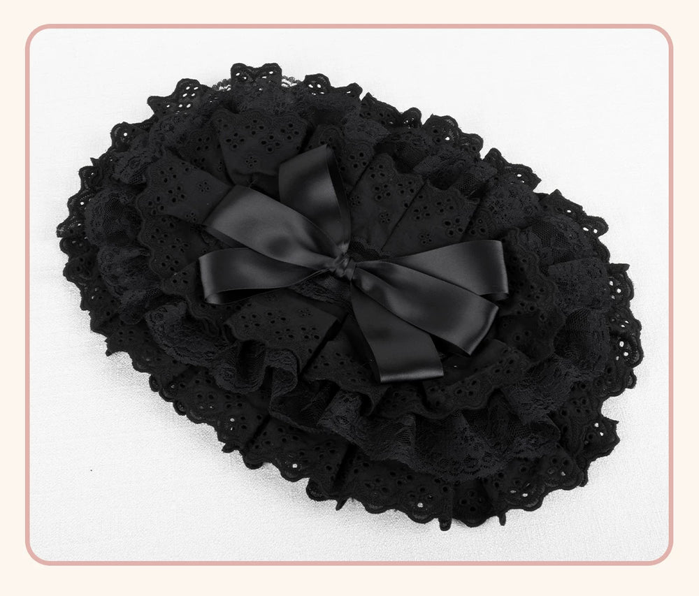 Black BNT flat hat with layered lace trim and ribbon bow displayed on a white background.