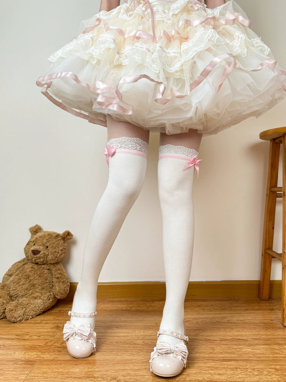 Chubby Bear Tales white socks with pink side bows, shown in an over-the-knee length beneath a layered skirt.