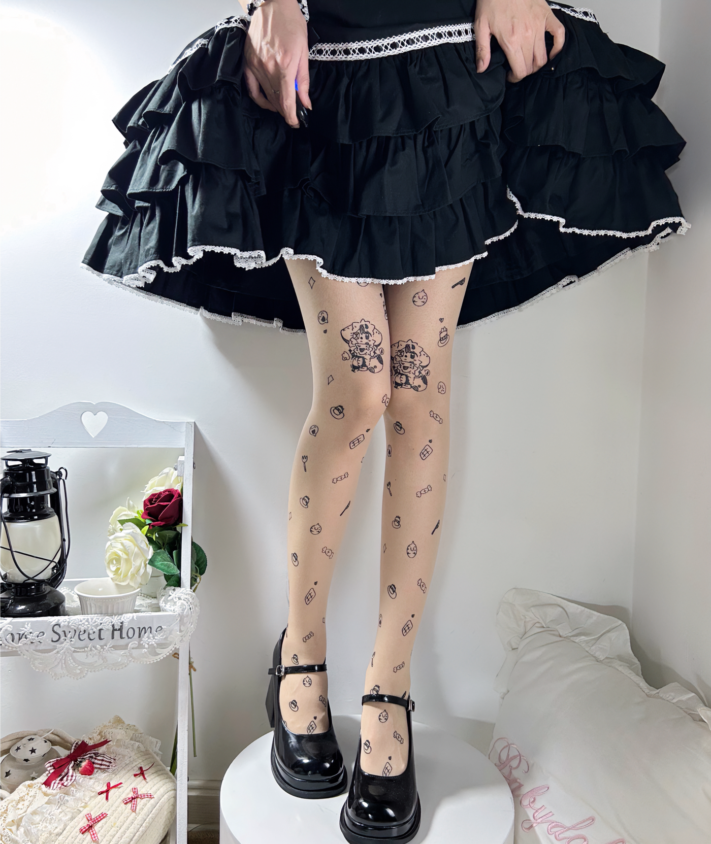 Printed tights with scattered cartoon, candy and small face motifs styled with a black ruffled skirt.