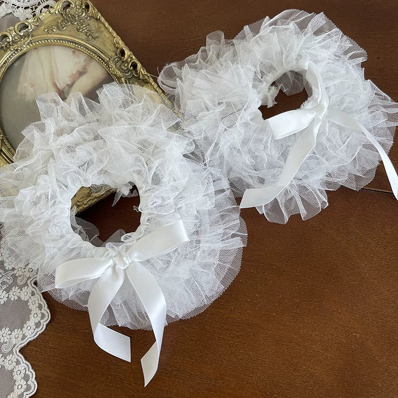 White ruffled lace foot covers with satin ribbon bows.