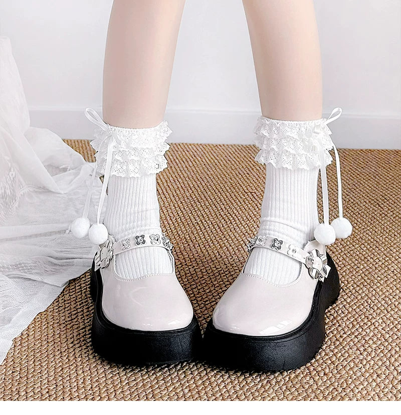 White mid-calf socks with lace cuffs, ribbon ties and pom-pom accents