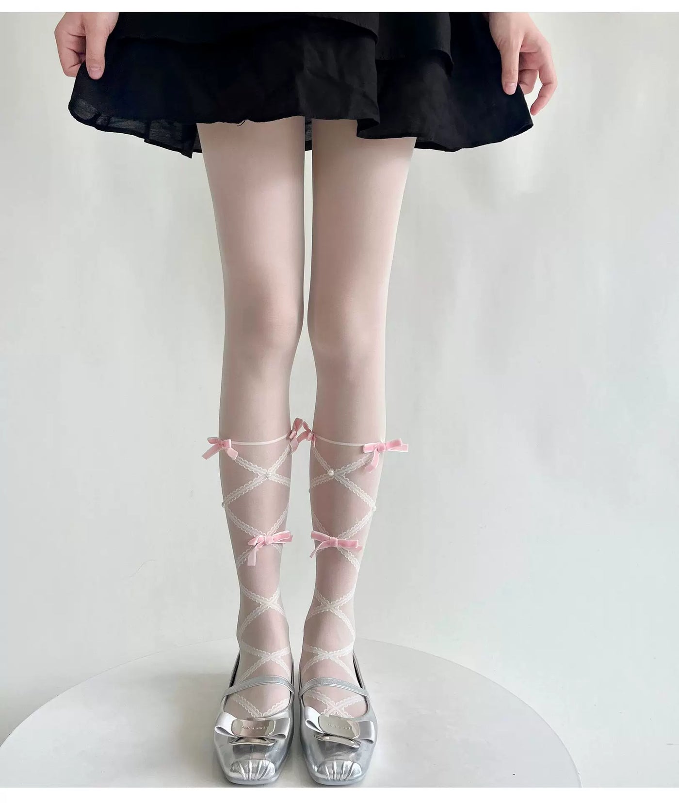Close-up of pink bow and white lace detail on sheer Lolita tights