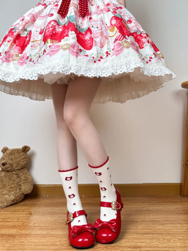 White mid-calf socks with strawberry, cat, floral, and red bow motifs styled with red shoes.