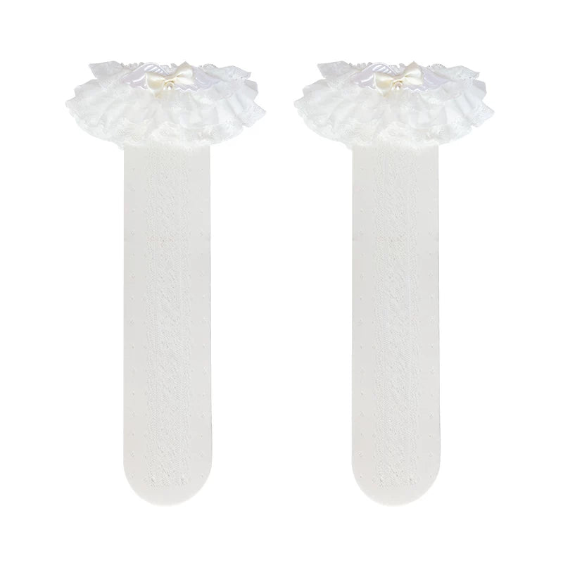 White lace socks with layered ruffles, bow and pearl details worn on the legs.