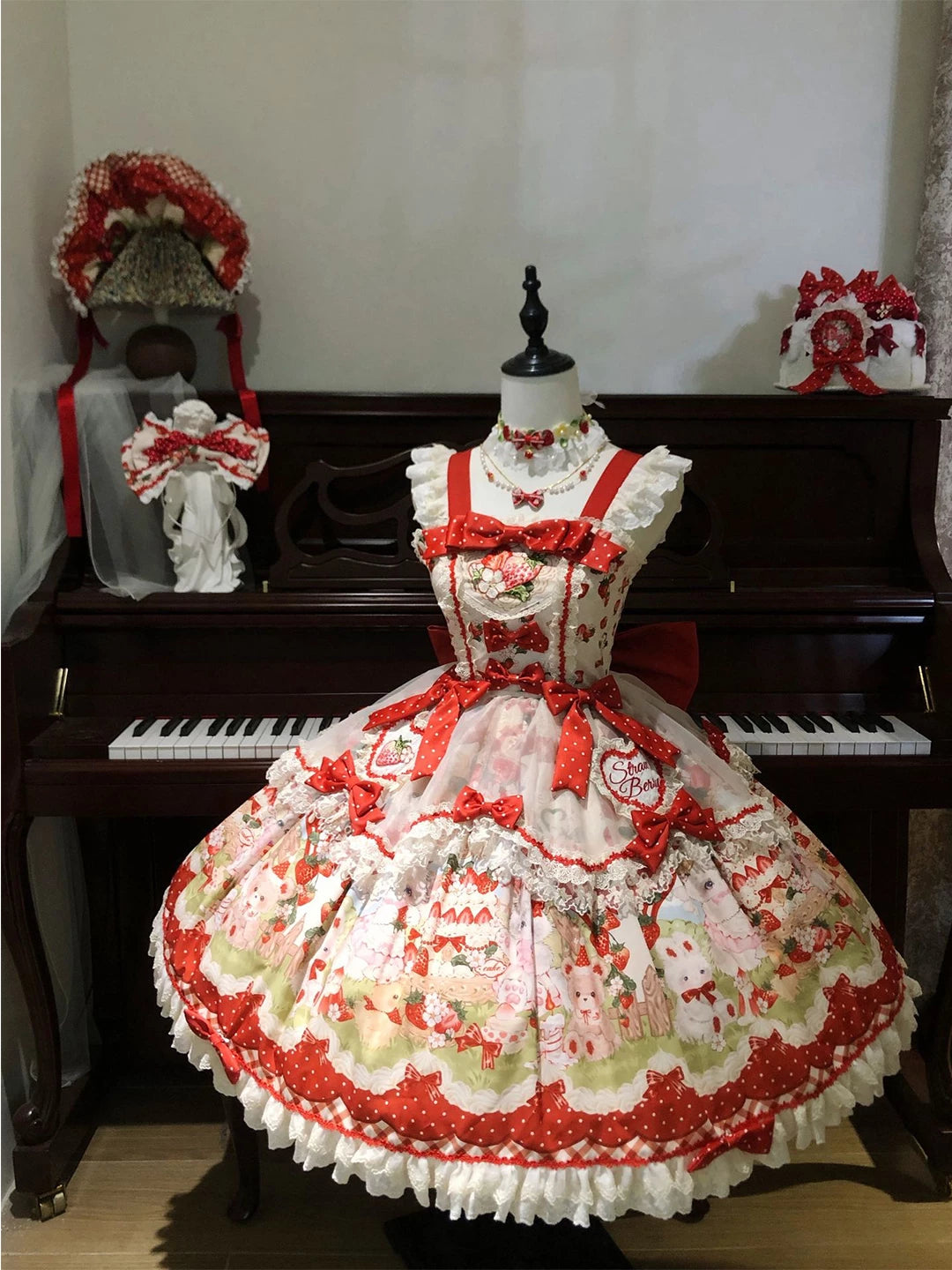 Creamy strawberry-and-cat print jumper skirt set with red bows and lace trim on a mannequin