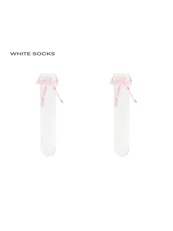 Pair of white lace-trimmed socks with pink ribbon bows shown isolated on white.