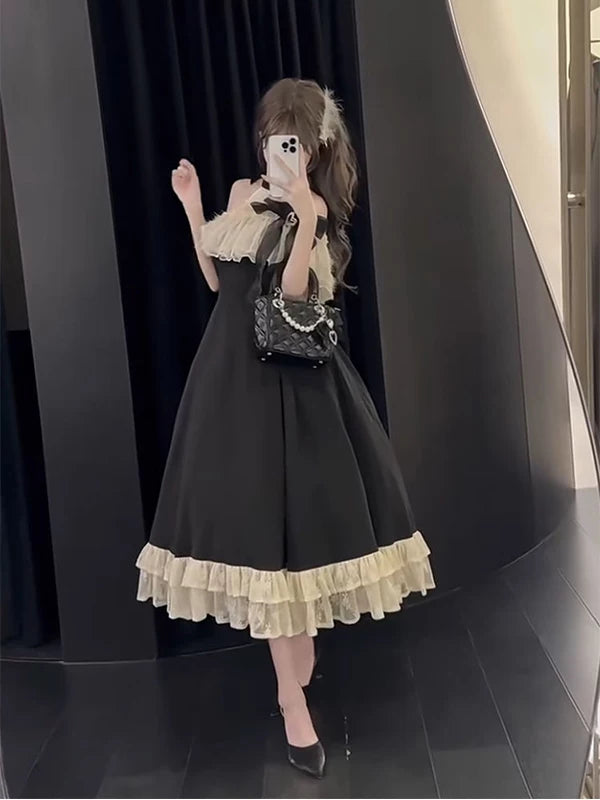 Model wearing a black-and-white one-piece Lolita dress with white ruffled trim.