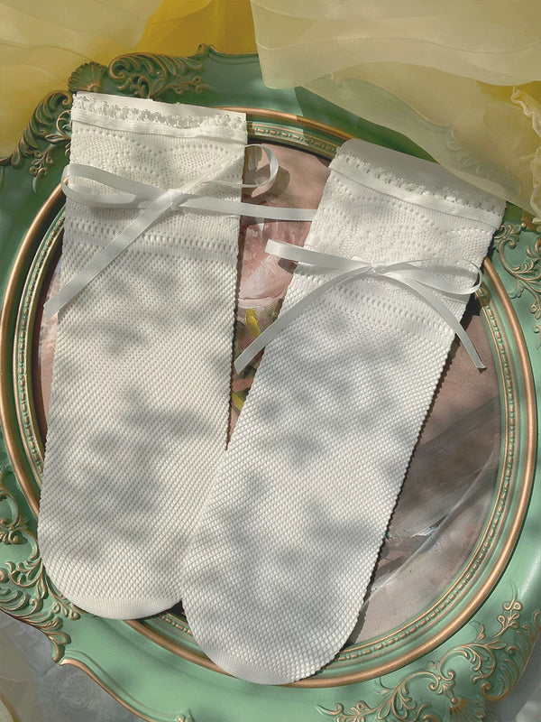 Natural white sheer lace-trim socks with ribbon bows in a romantic interior