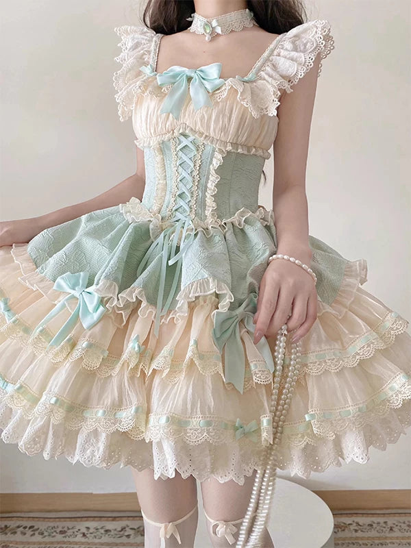 Model wearing a green tiered JSK with lace and pale aqua bows.