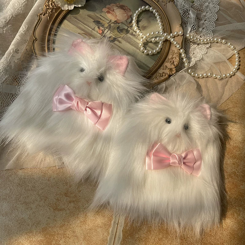 White furry cat-inspired leg warmers with pink ears and pink bows arranged on lace fabric
