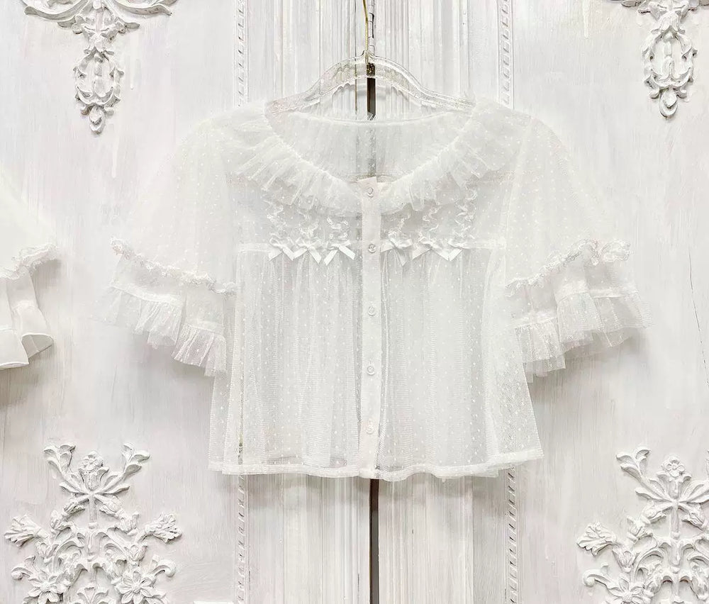 Off-white dotted mesh short-sleeve blouse with ruffled collar and layered lace-trim sleeves on a hanger.