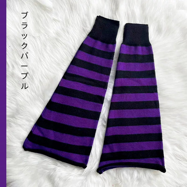 Pair of black-and-purple striped leg warmers laid on white faux fur.