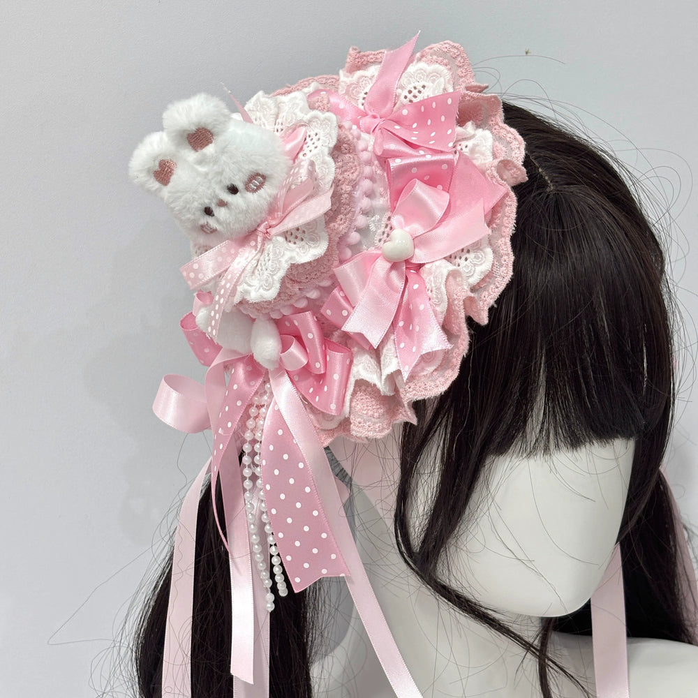 Pink lace rabbit-themed headwear with layered bows and pearl strands on a model head.