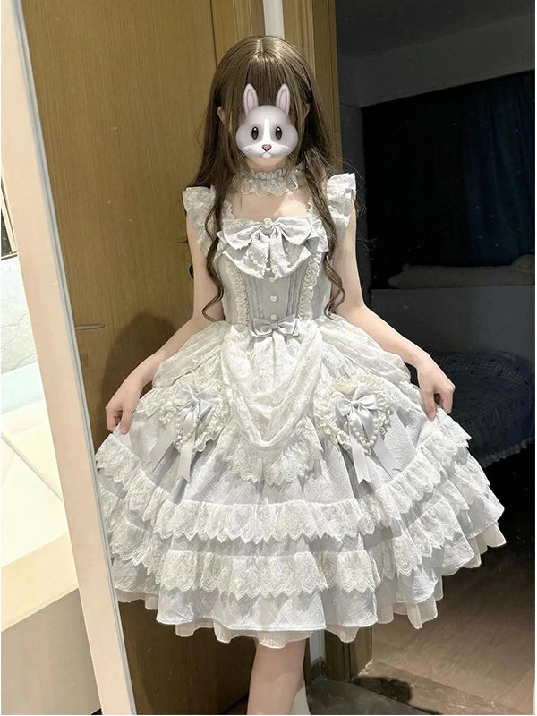 Front view of pale blue sweet lolita tiered lace dress with bow accents and train