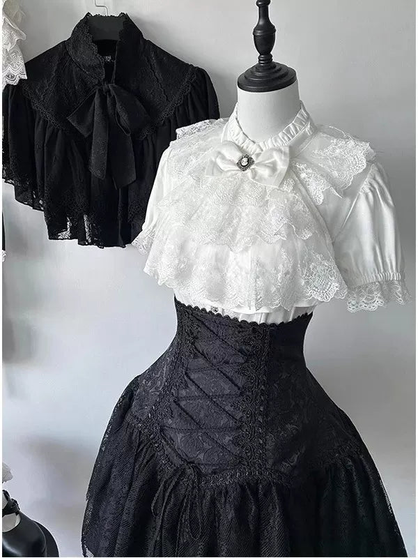 Black-and-white blouse, lace bib and short skirt set displayed on a mannequin