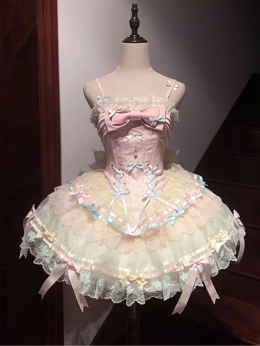 Pastel balletcore sweet lolita JSK with corset lacing, large central bow, and layered ruffled skirt