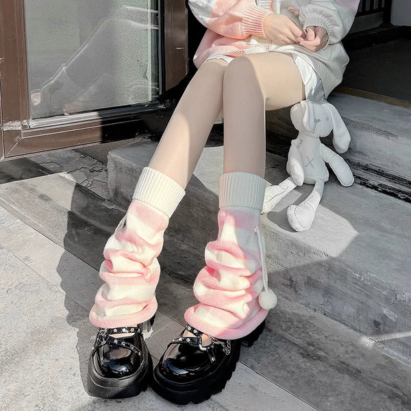Pink-and-white striped leg warmers with pom-poms shown with black platform shoes.