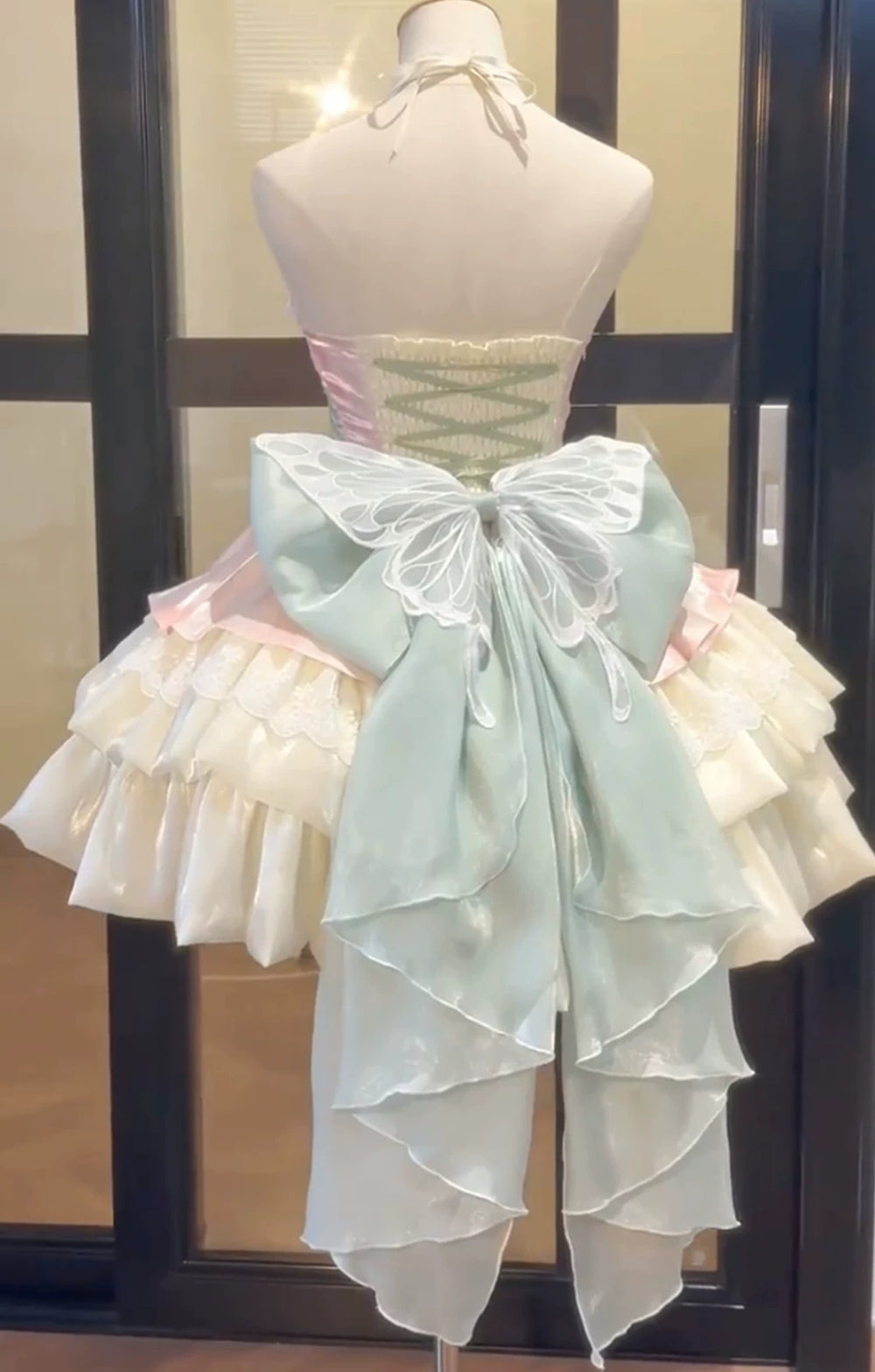 Powder green halter JSK with layered skirt and oversized back bow on a mannequin.