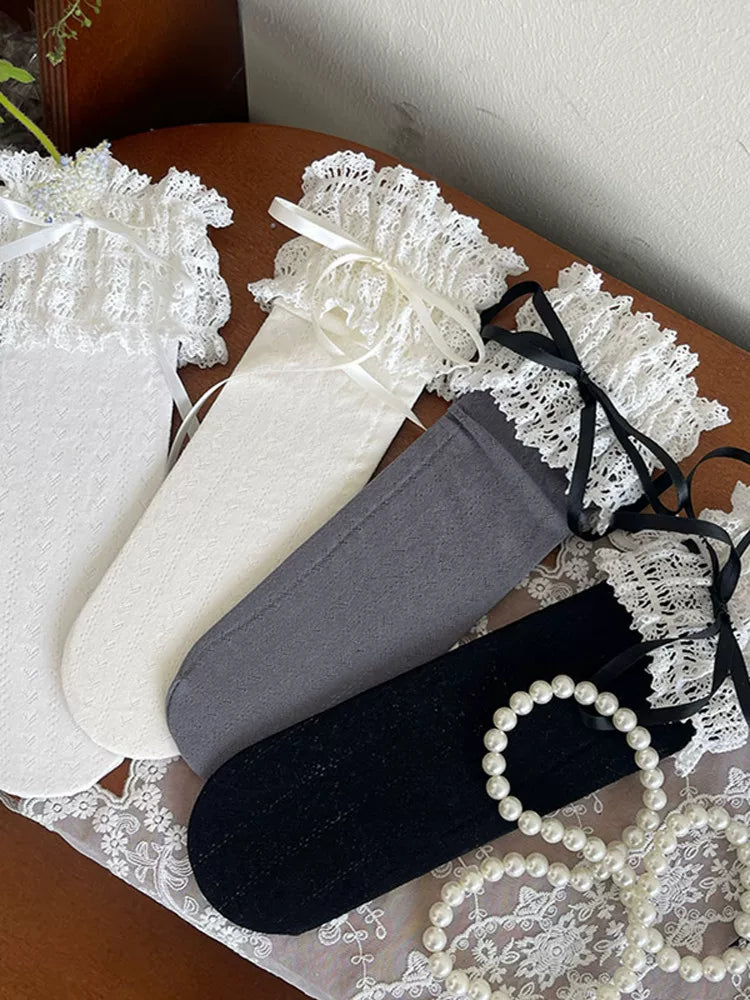 Lace-trimmed mid-calf socks with white bows worn with black platform shoes.