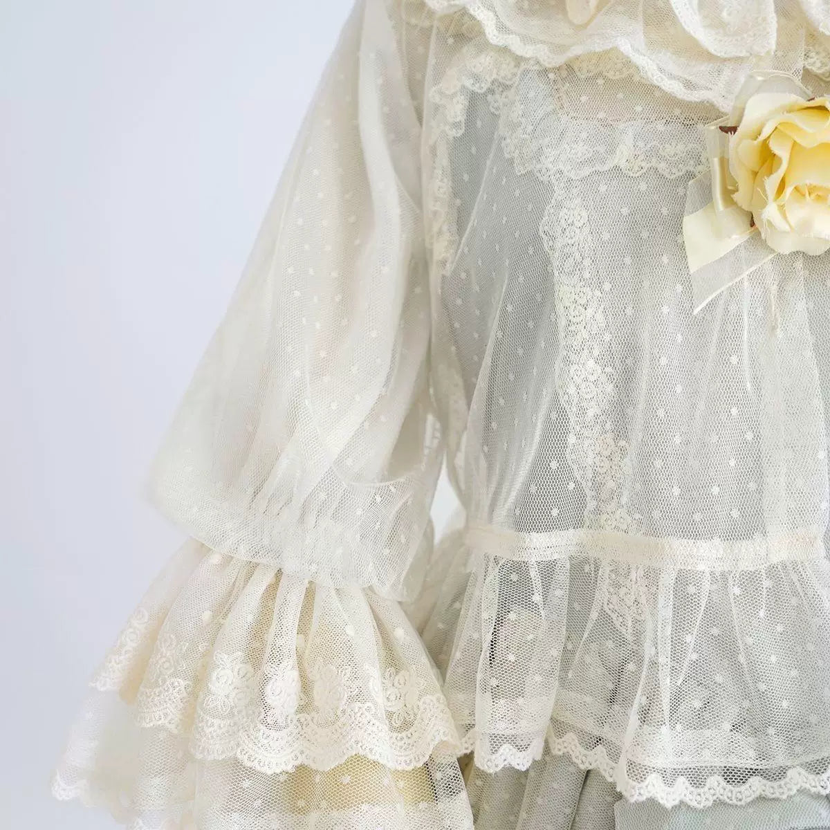 White mesh cover-up with dotted texture, ruffled sleeves and lace edging.
