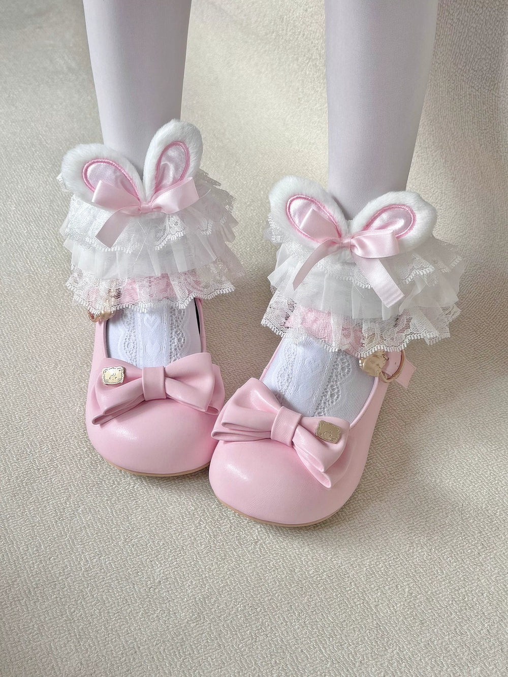 White socks with pink bunny-ear cuffs, bows and layered lace, worn with pink shoes.