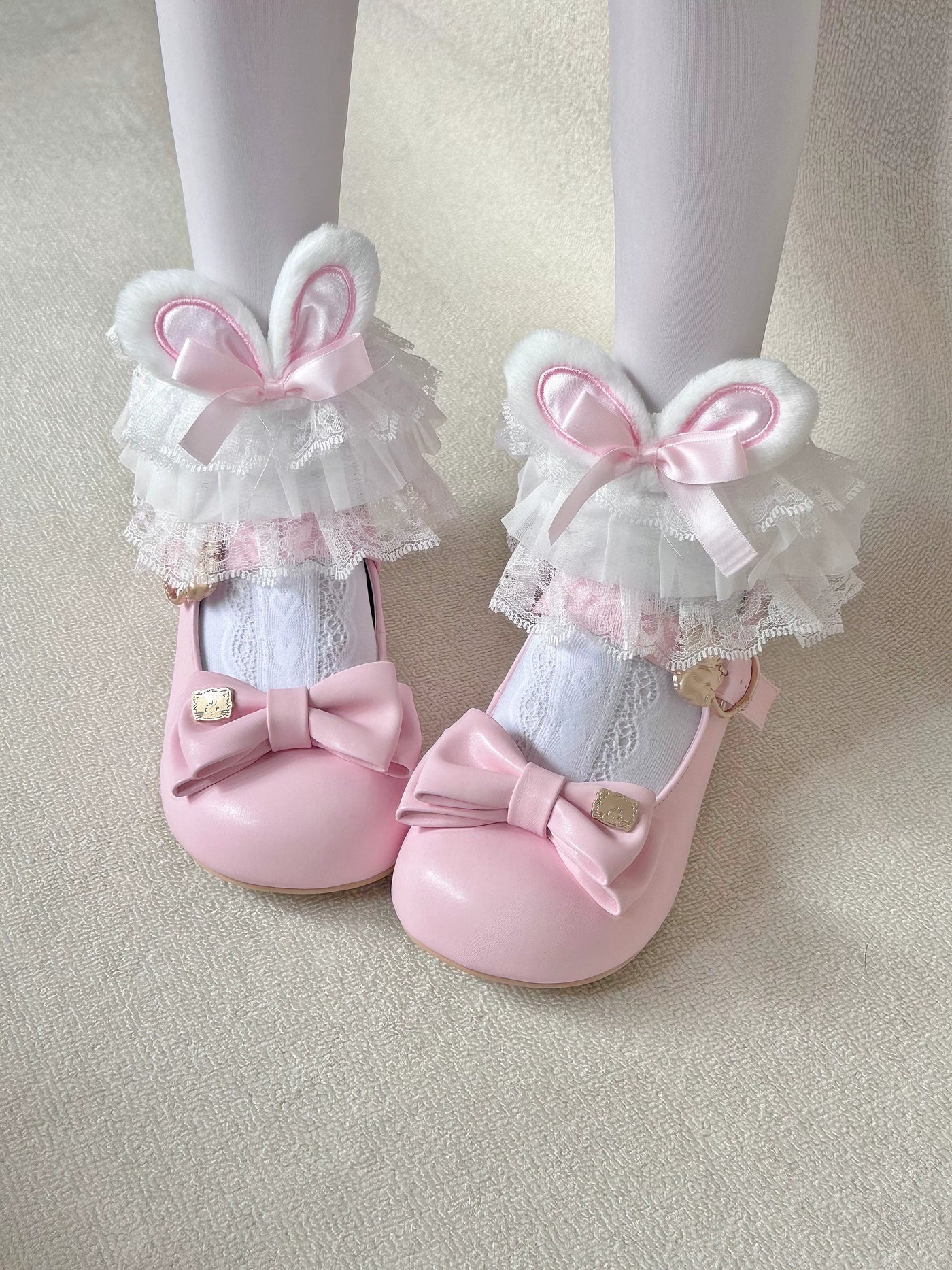 White socks with pink bunny-ear cuffs, bows and layered lace, worn with pink shoes.