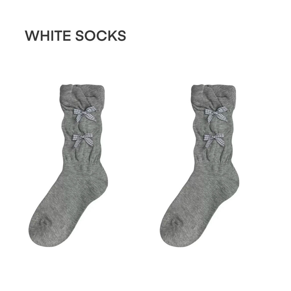 Grey slouch socks with small bow accents styled with silver Mary Jane shoes.