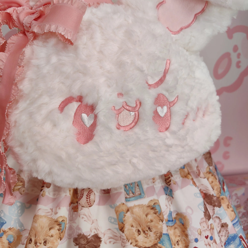 White plush rabbit backpack with long ears and pink ribbon, shown on a mannequin.
