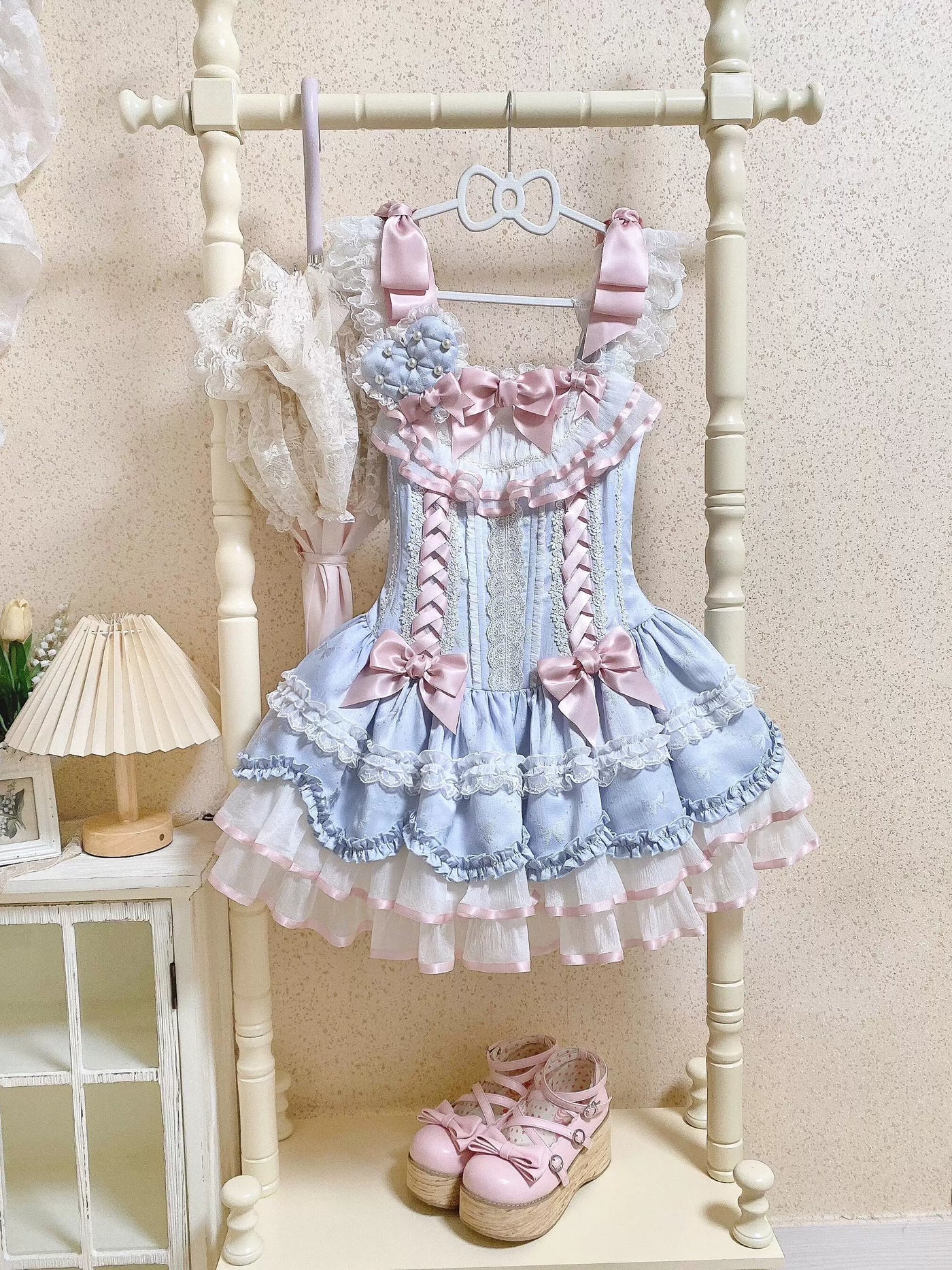 Blue JSK dress with layered ruffles, white lace trim, and pink bows.