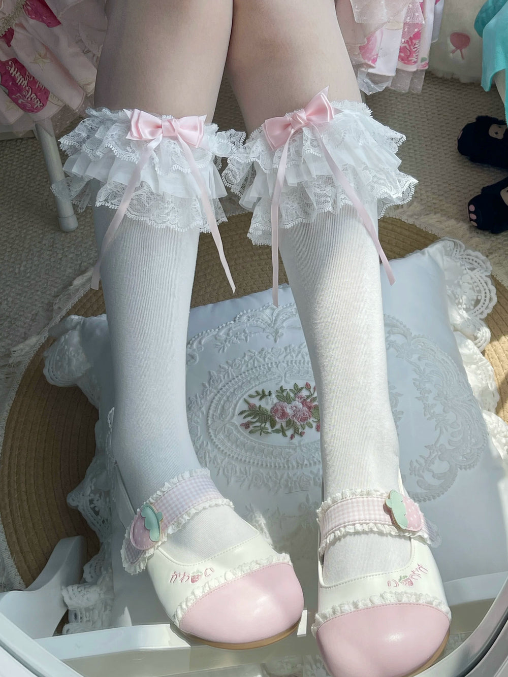 White layered lace socks with pink bows styled with white Mary Jane shoes