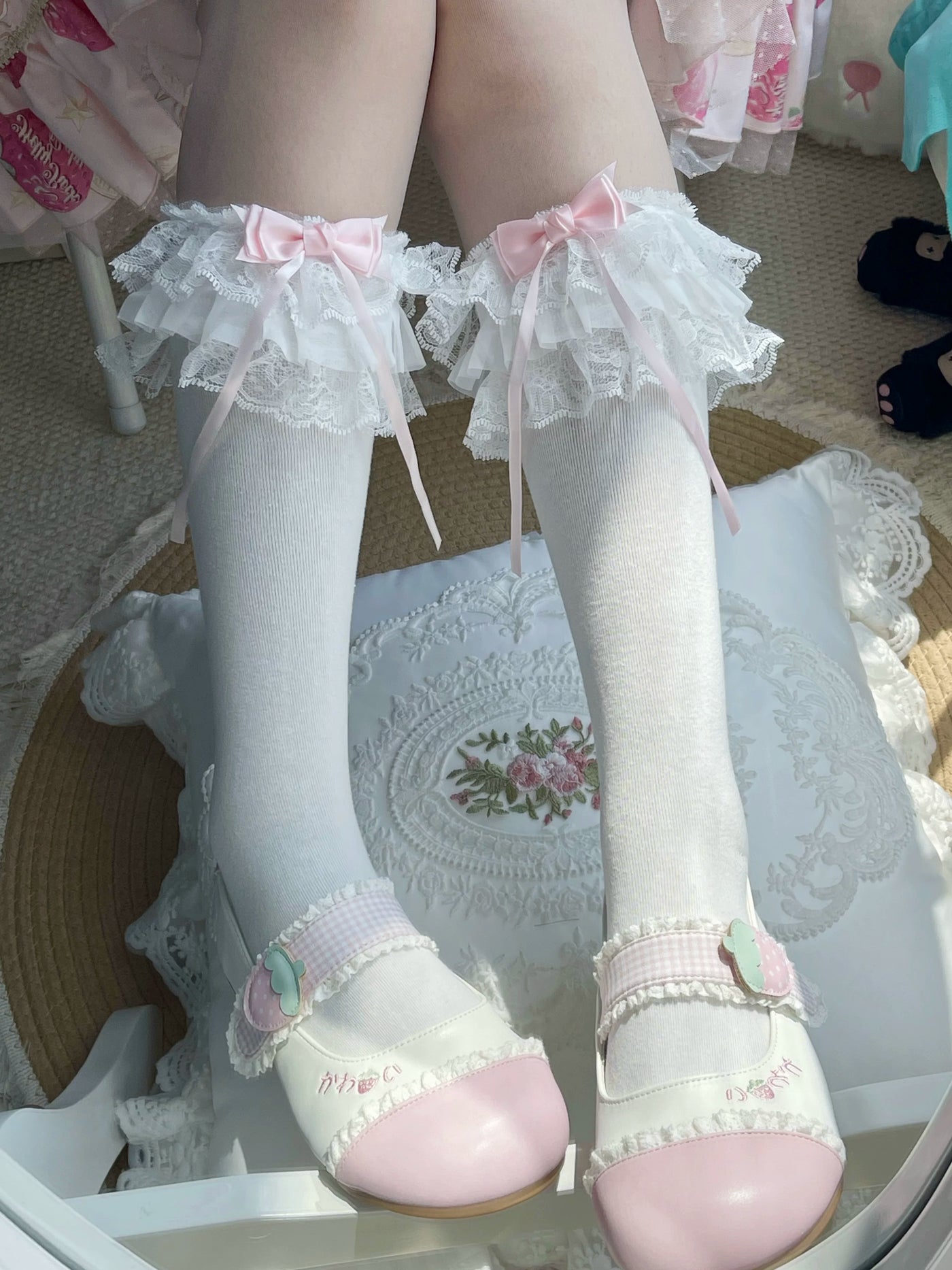 White layered lace socks with pink bows styled with white Mary Jane shoes