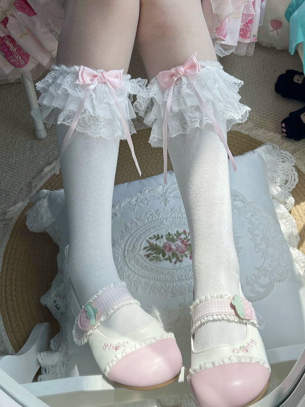 White layered lace socks with pink bows styled with white Mary Jane shoes