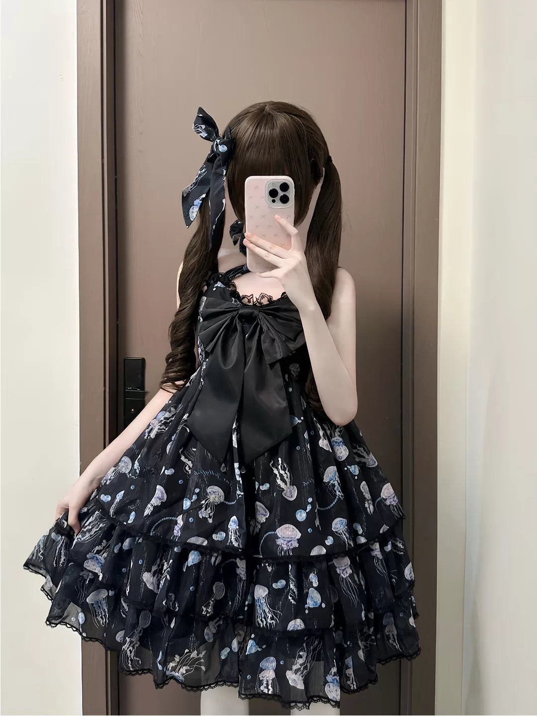 Black jellyfish-print JSK with a large bow and layered ruffled skirt worn in a mirror view.