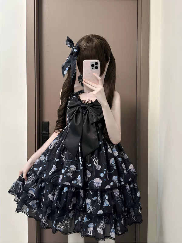 Black jellyfish-print JSK with a large bow and layered ruffled skirt worn in a mirror view.